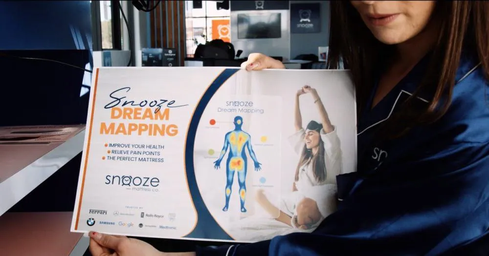 Snooze Sleep Coach holding a Snooze Dream Mapping board